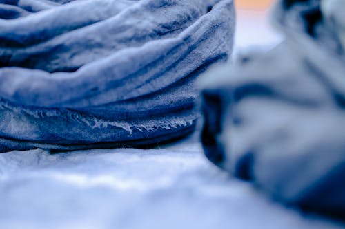 Creased blue linen textile prepared for sewing handmade fabrics and clothes in craft workshop
