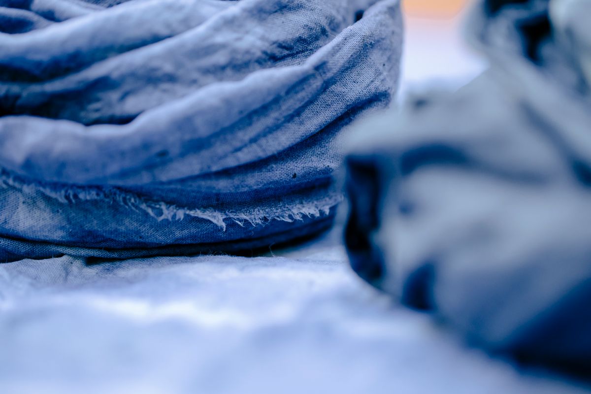 Close detail of blue-dyed cotton, colour uneven across the weave