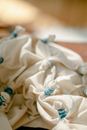 High angle of white creased fabric tied with threads in sewing workshop for designing handmade clothes