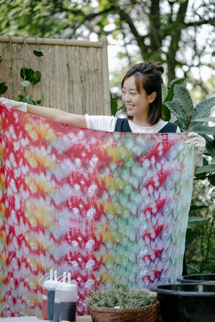 Cheerful Asian Woman With Painted Fabric