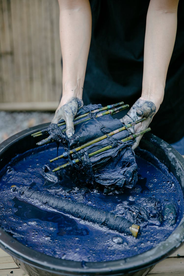 Anonymous Person Dyeing Textile On Street