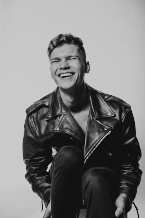 Grayscale Photo of a Man in Leather Jacket Laughing · Free Stock Photo