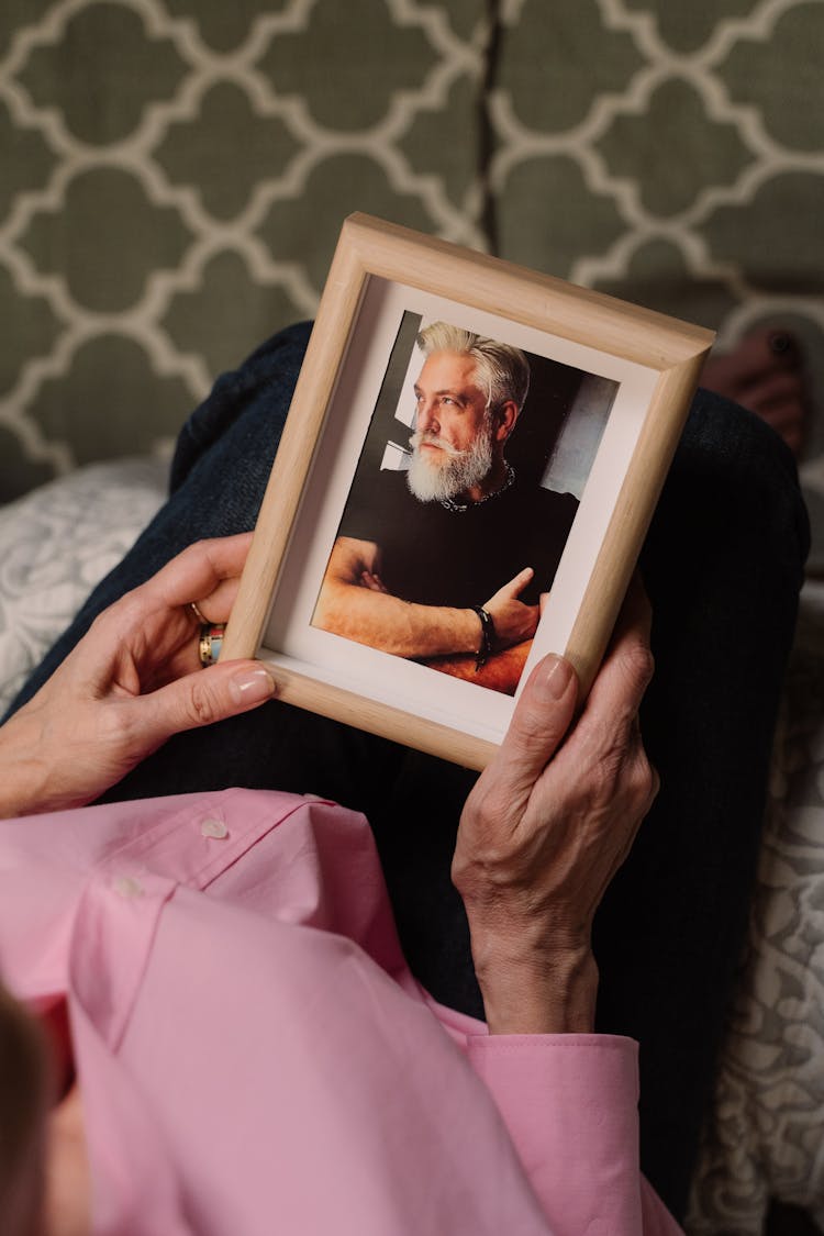 Person Holding A Wooden Framed Photo Of Man