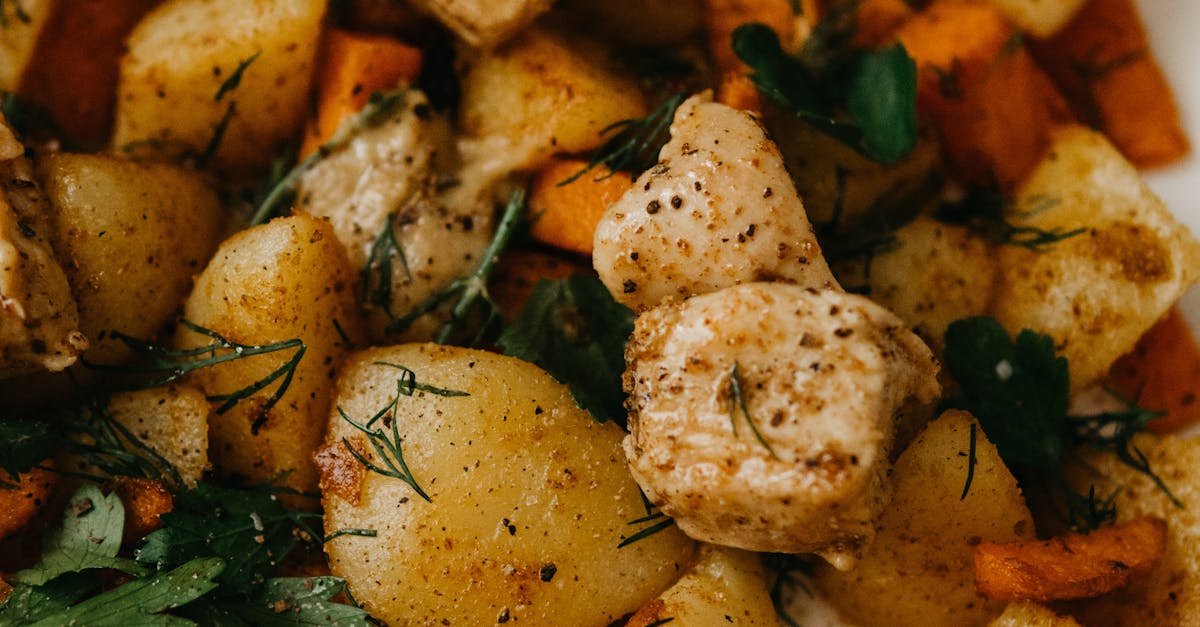 Delicious dish with fried potatoes and carrots served with herbs
