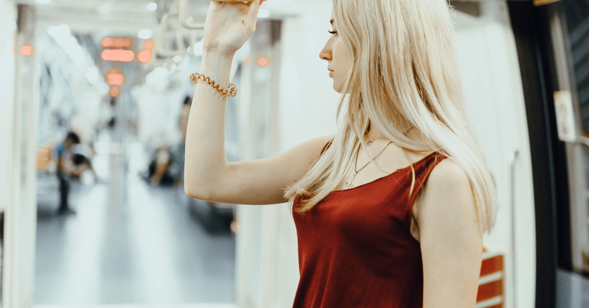 Woman Using Handrail Young woman holding handrail while commuting by contemporary train ...