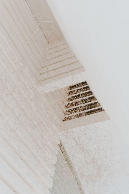 From below of minimalist geometric ceiling with creative thin wire chandelier in daylight