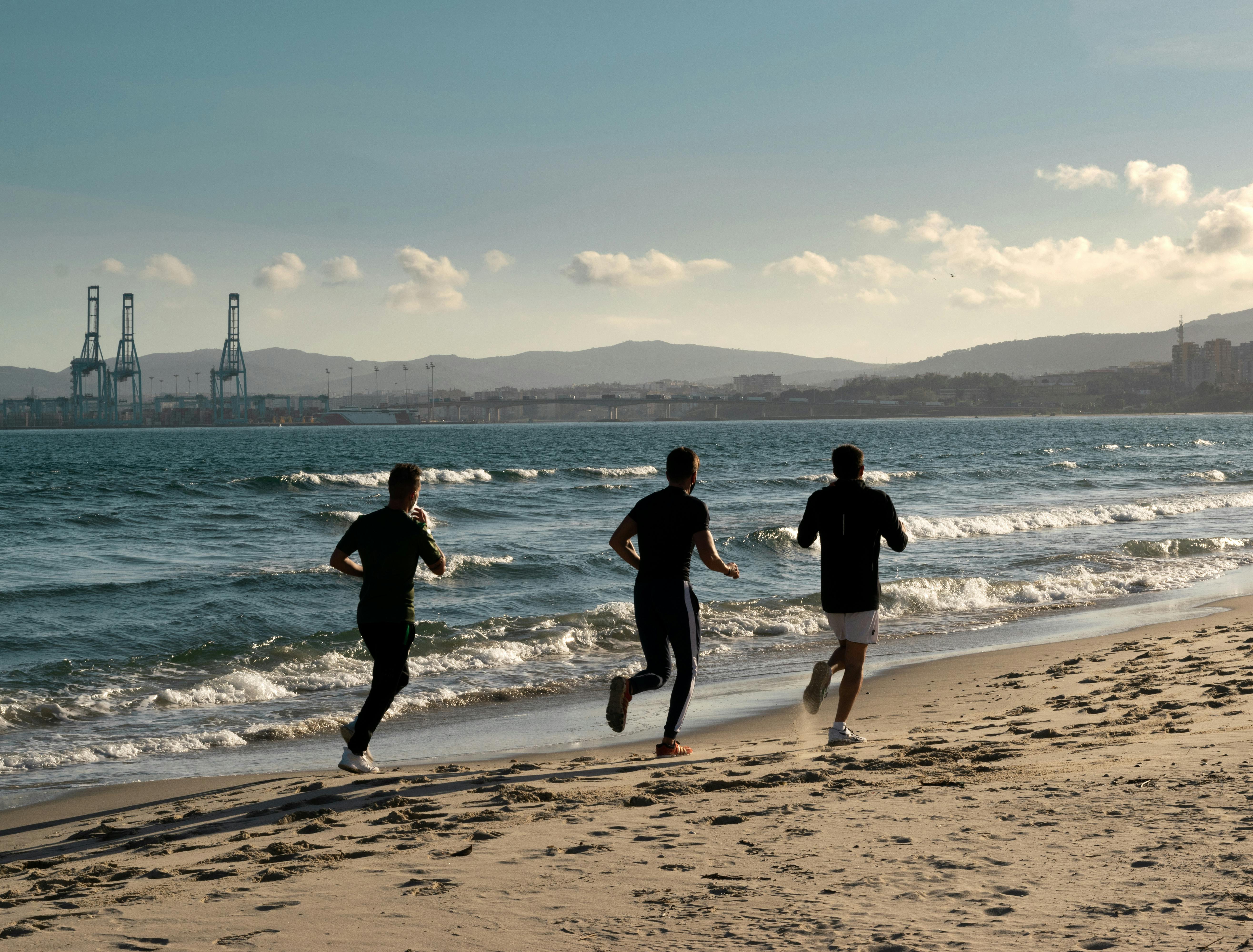 Free Men Running at the Beach Stock Photo