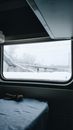 Window of train with picturesque view on snowy bridge in city