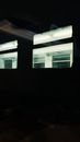 View through glass window on dark empty train with illuminated windows in evening time