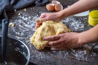 Person Making Dough on Brown Wooden Table