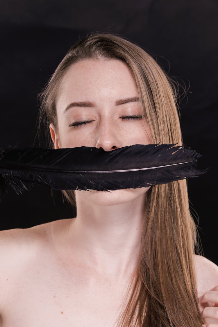 A Lady Covering Her Lips Black Feather