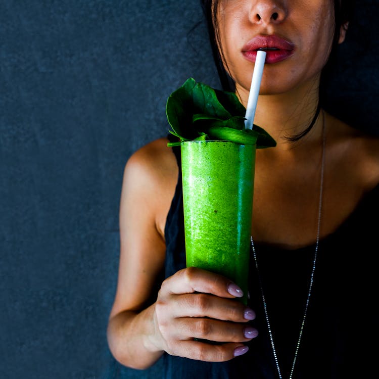 Woman In Black Tank Top Holding A Green Smoothie