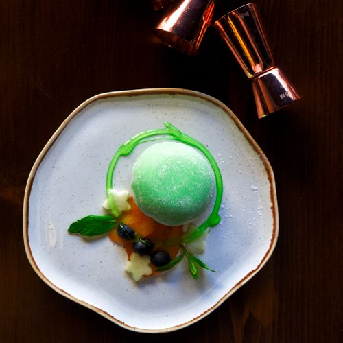 Free Delicious green sorbet with artistic garnishes on a ceramic plate, captured in a top view. Stock Photo