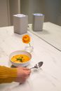 Person Holding Stainless Steel Spoon and White Ceramic Bowl With Soup