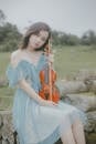 Woman Wearing Dress Holding a Violin
