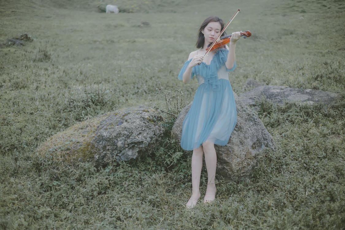 Free Woman in Blue Dress Playing Violin Stock Photo