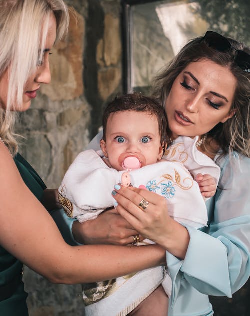 Mother with little baby in arms near friend