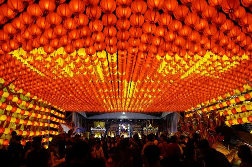 People Standing Near Orange Paper Lanterns during Night Time