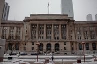 Facade of famous office building with flag located on street near modern skyscrapers on cold winter day in Toronto city