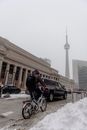 Unrecognizable man riding bicycle near Dominion building