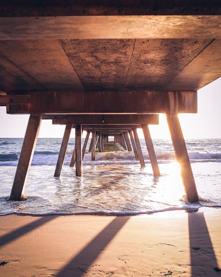 Photo Of Waves Under A Wooden Dock On Sea