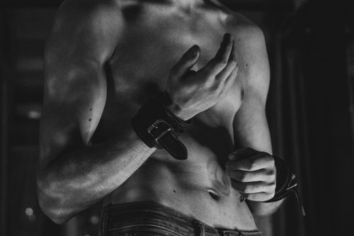 Free Black and white image of a shirtless man wearing handcuffs, conveying a moody and muscular vibe. Stock Photo