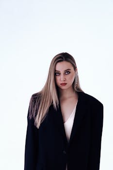 A striking studio portrait of a young woman in a stylish jacket, exuding confidence.