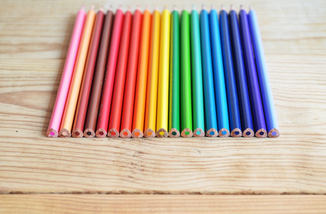 無料 茶色の木の板にさまざまな色の色鉛筆 写真素材