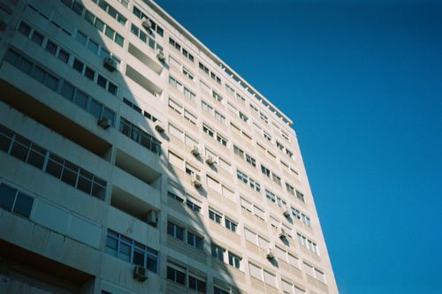 Free A detailed view of a Lisbon building's facade against a vibrant blue sky, showcasing modern architecture. Stock Photo
