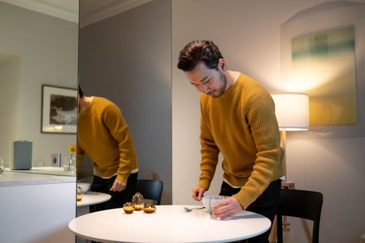 A man arranging a table in a stylish, modern, and minimalist interior setting, captured indoors.