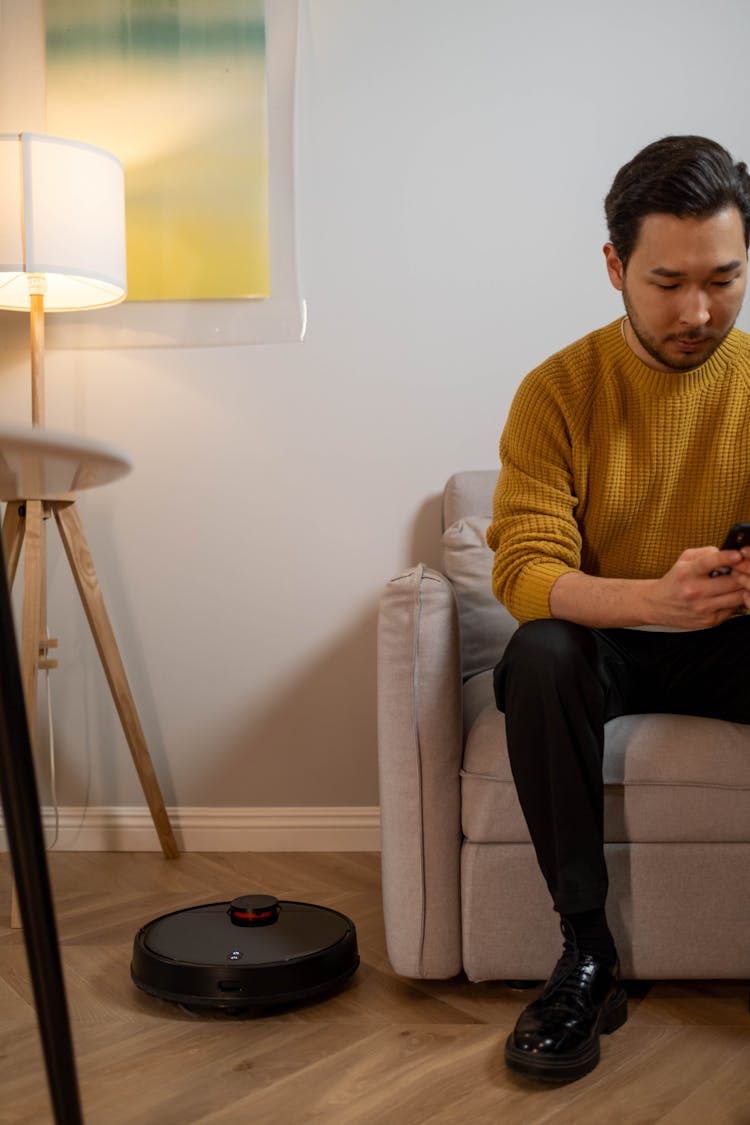 Man In Brown Knit Sweater Sitting On Sofa Using Phone 