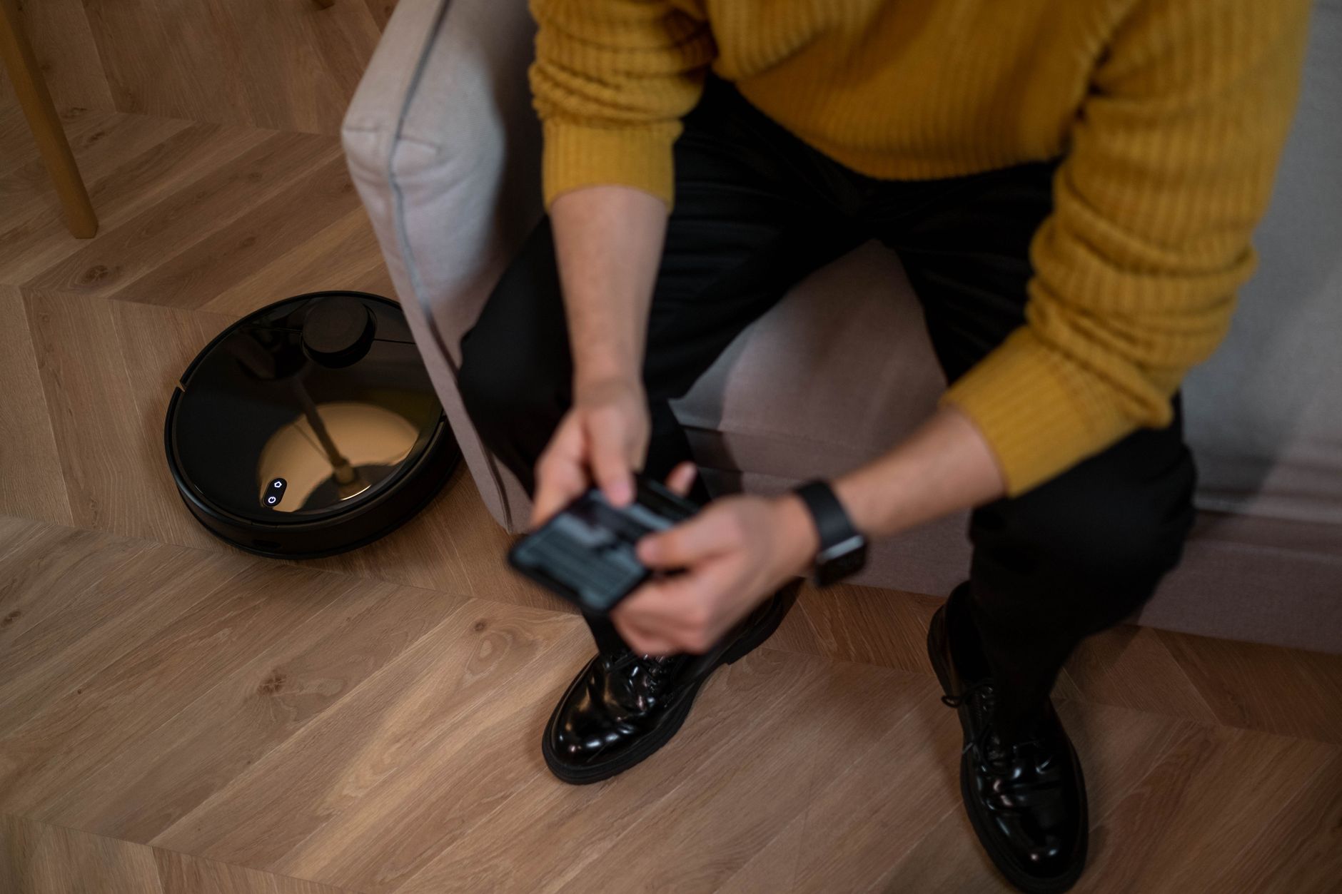Man controlling robotic vacuum