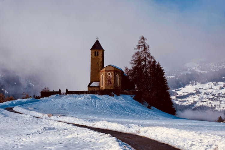 Old Church With Bell Tower Against Road In Winter