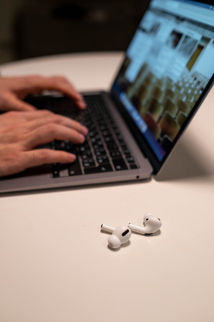 Airpods Pro Beside A Laptop 