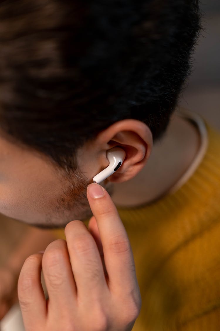 Person In Yellow Sweater Wearing An Airpods Pro 