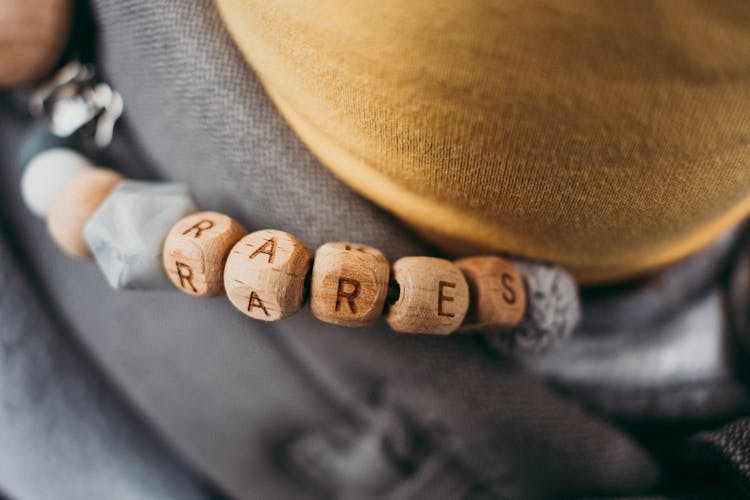 Close-up Of A Bracelet With Wooden Beads And Letters 