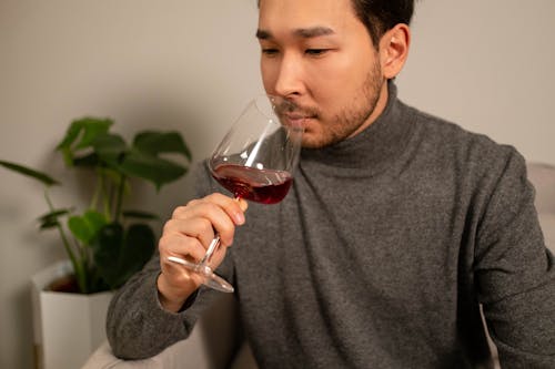 Free Close-Up Photo of a Man Smelling Red Wine on a Glass Stock Photo