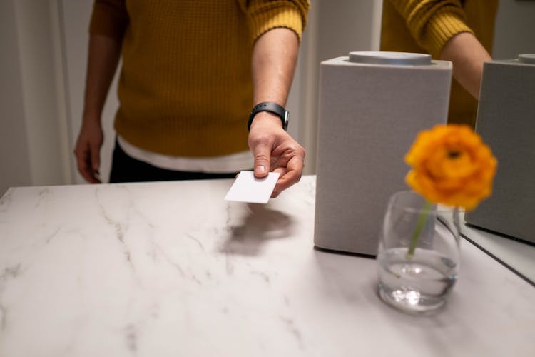 Person In Yellow Knitted Sweater Holding A White Card 