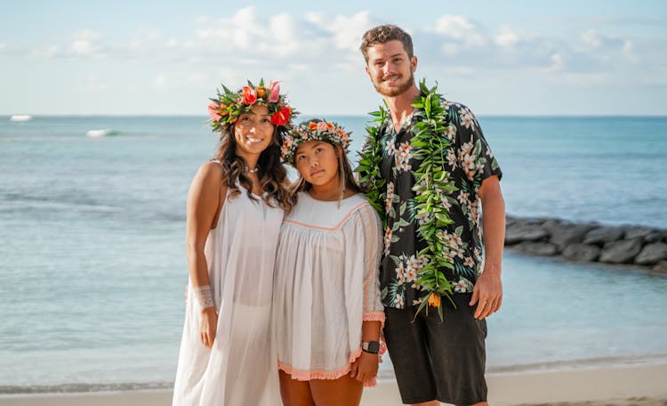 Cheerful Diverse Couple And Friend Standing Together On Sandy Beach