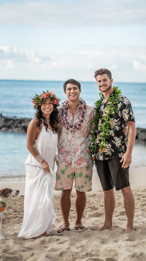Free Happy newlywed diverse couple and friend standing on beach and Stock Photo