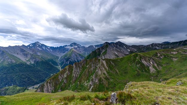 Stunning view of the Alps with dramatic clouds and lush greenery showcasing beautiful nature.