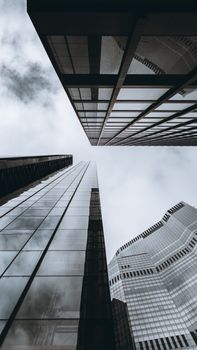 Dynamic low angle shot capturing London's modern skyscrapers against a cloudy sky.