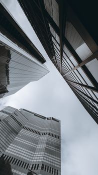 A striking low-angle view of London's modern glass skyscrapers against a cloudy sky.