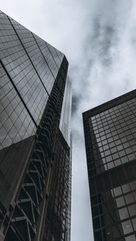 Monochrome view of London skyscrapers under a cloudy sky, highlighting modern architecture.