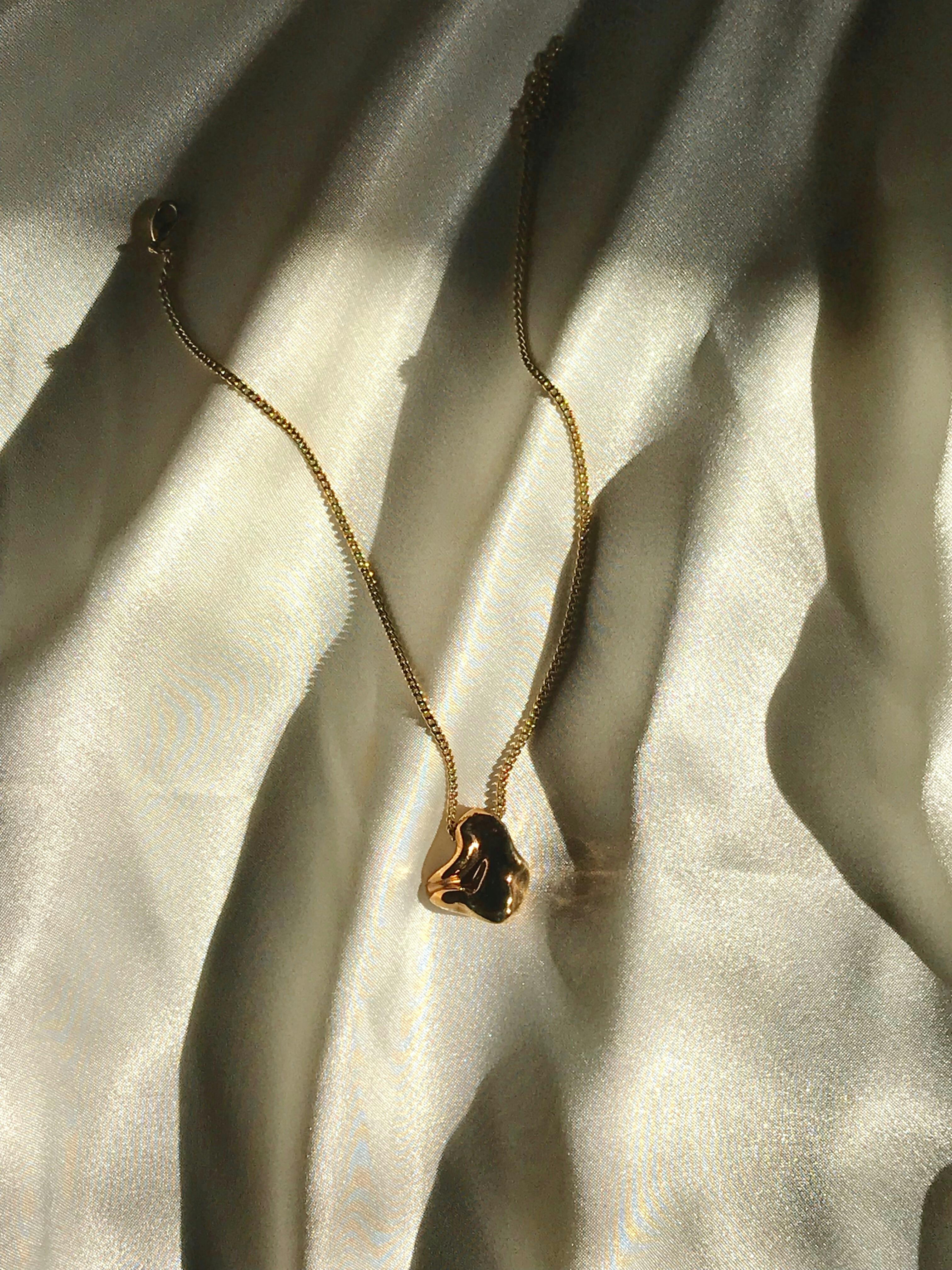 black gemstone pendant necklace on white satin textile