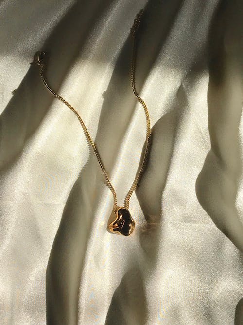 Black Gemstone Pendant Necklace on White Satin Textile