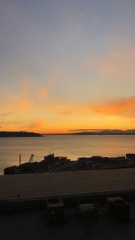 Spectacular view of sundown on cloudy sky above rippling river near shore with constructions