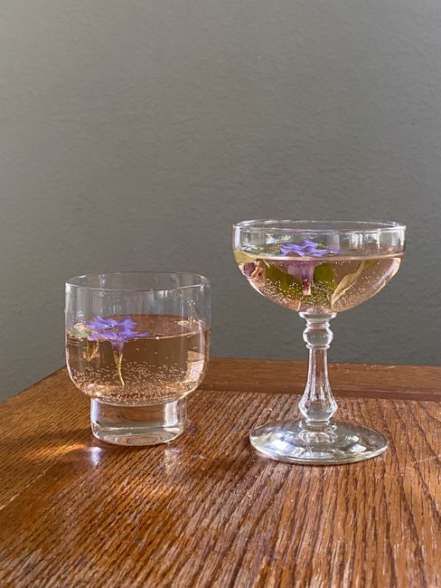 Transparent glasses filled with sparkling champagne placed on wooden surface near wall in light room