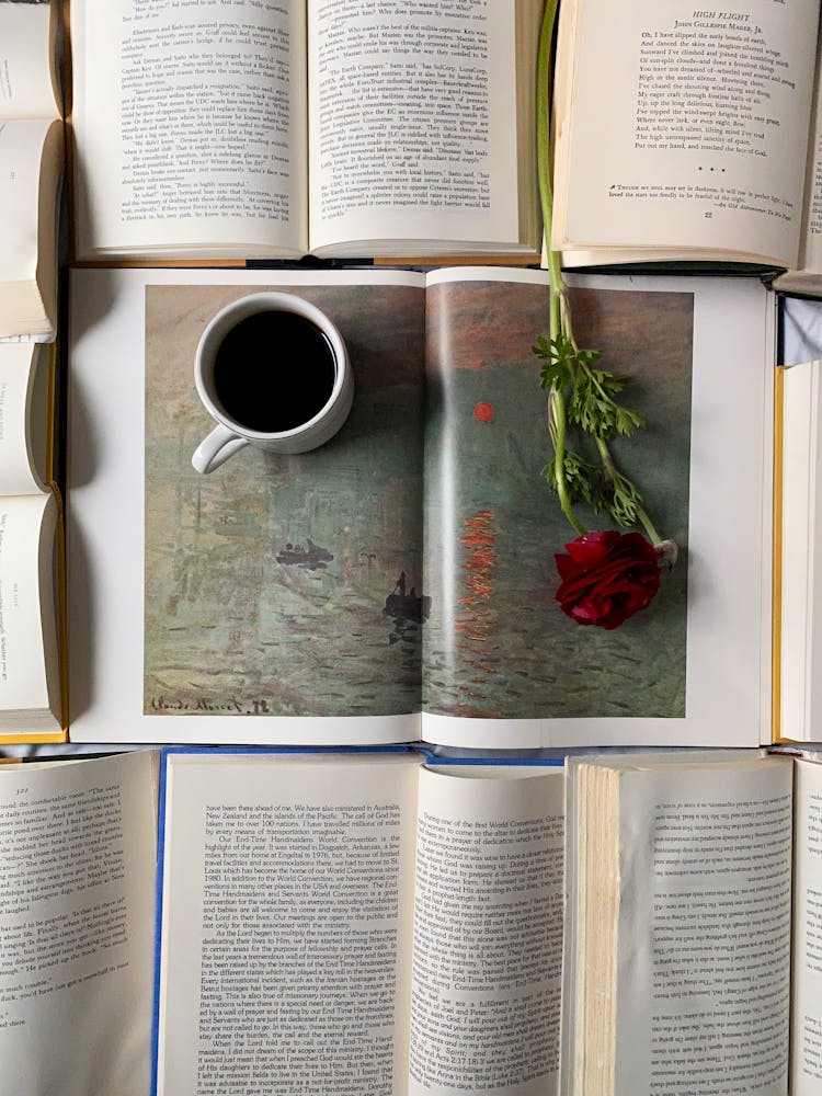 Cup Of Coffee And Red Rose On Opened Books