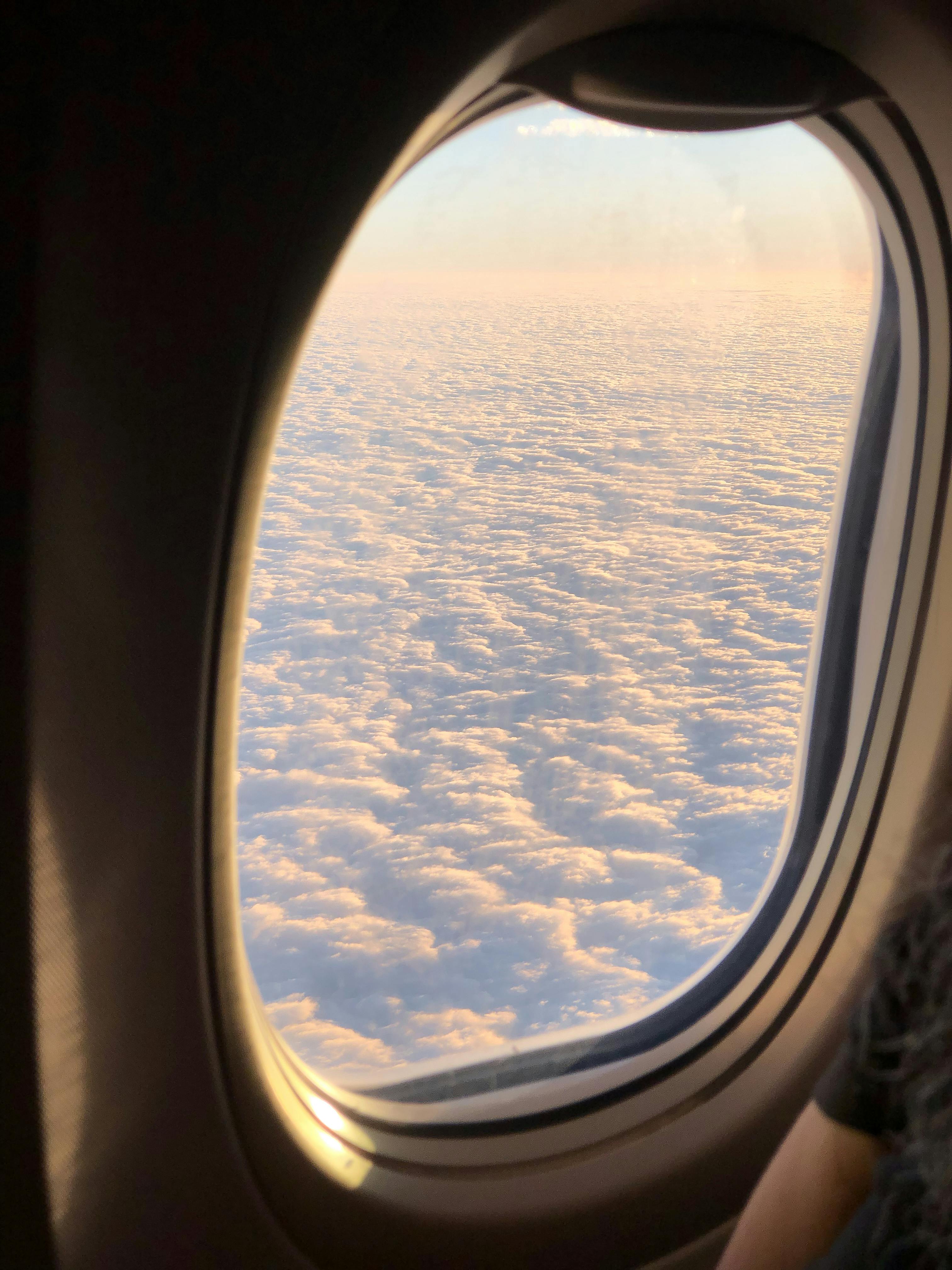 fluffy clouds though airplane window during flight